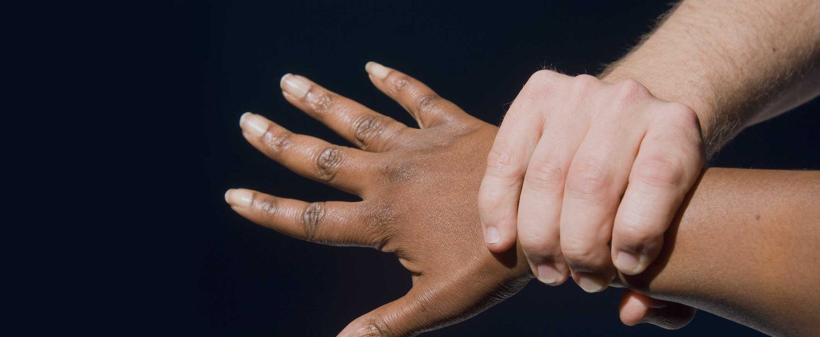 One hand gripping another person's wrist, the contact behind an assault and battery charge