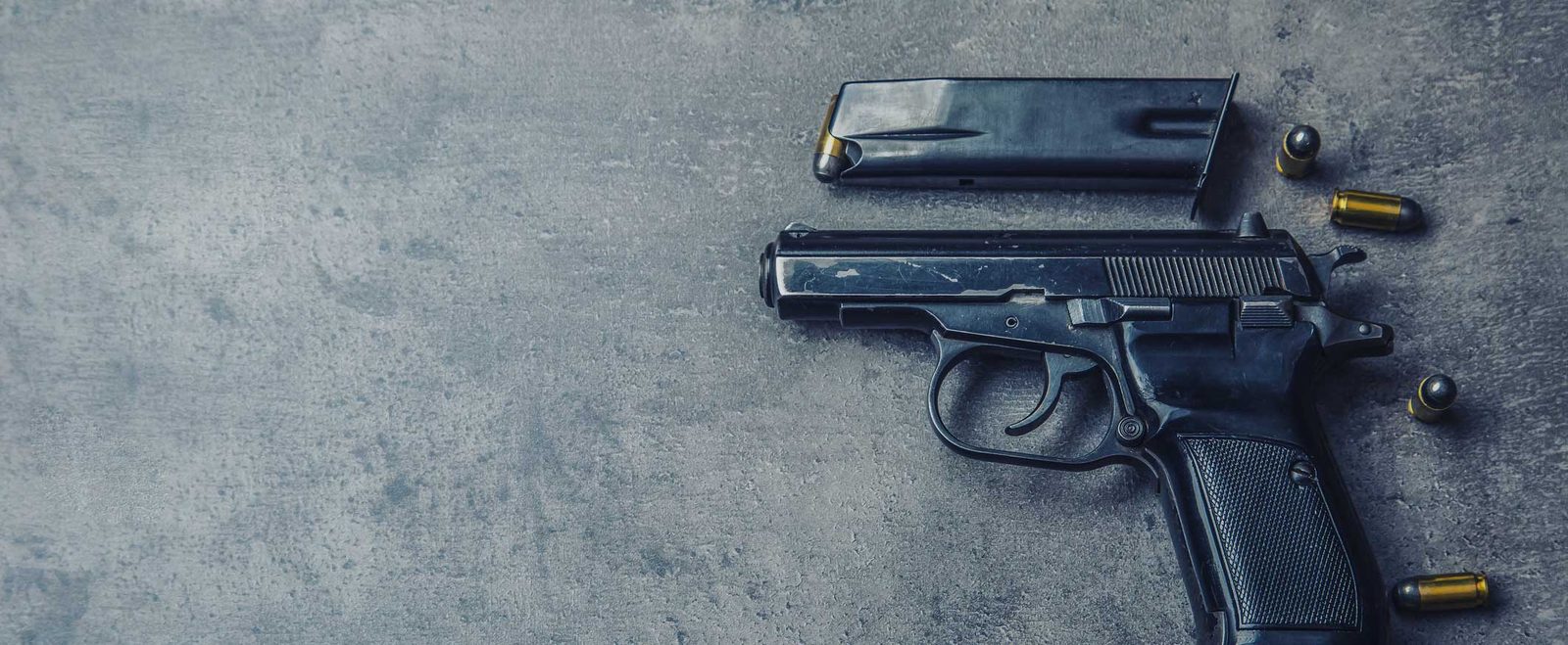 A handgun and loose bullets on concrete, the weapon in an assault with a deadly weapon charge