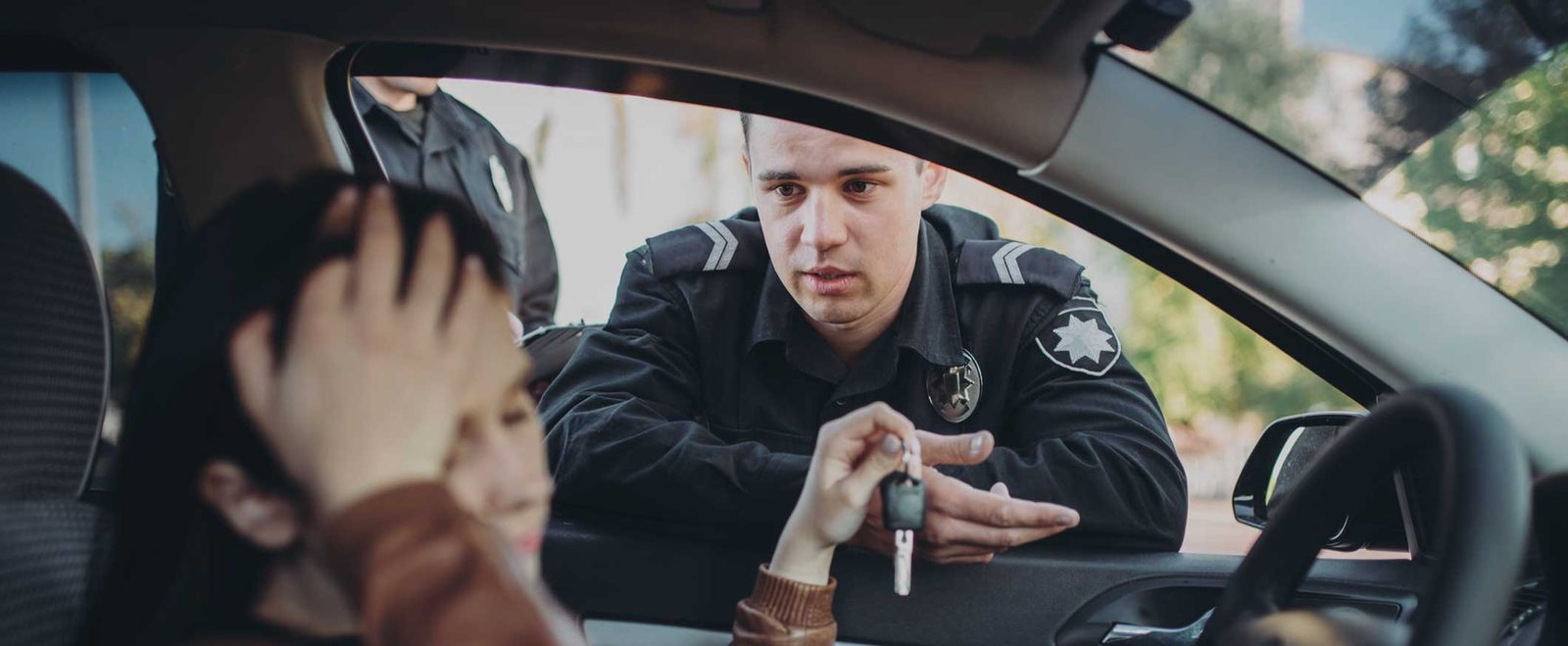 A police officer questioning a driver stopped for driving without a license
