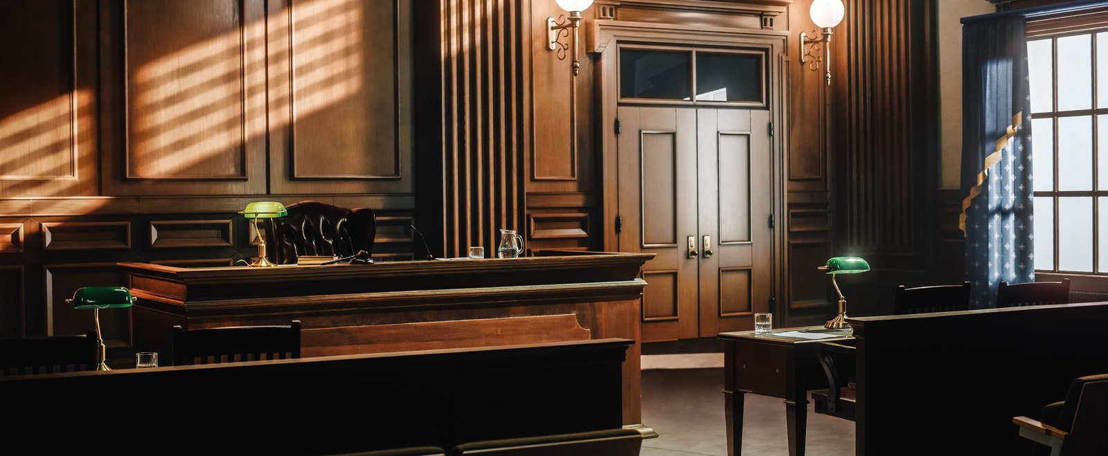 An empty courtroom with the judge's bench and counsel tables, where a homicide case is tried