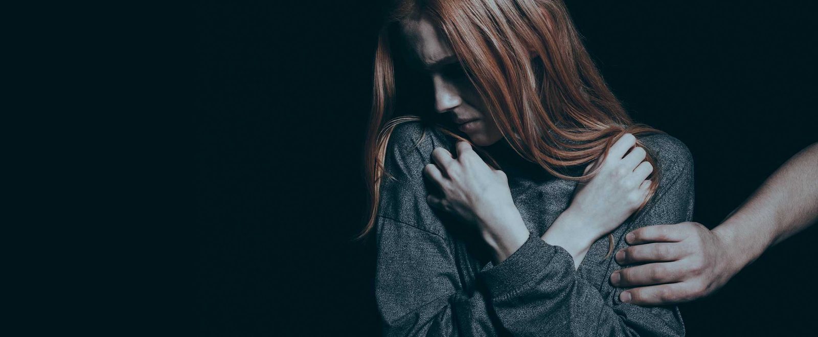 A woman shielding herself from a hand reaching for her shoulder in a sexual assault case