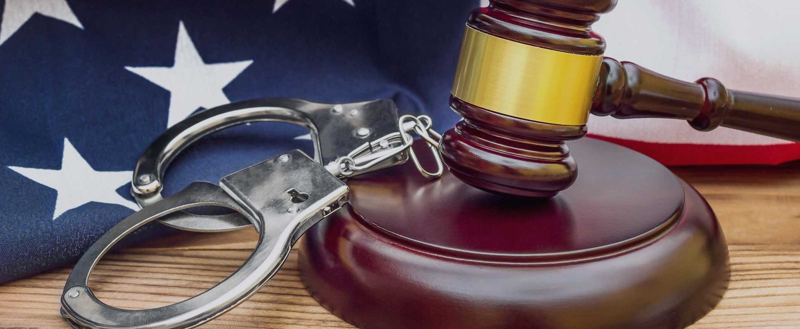 Handcuffs and a gavel on a United States flag, between state and federal crimes