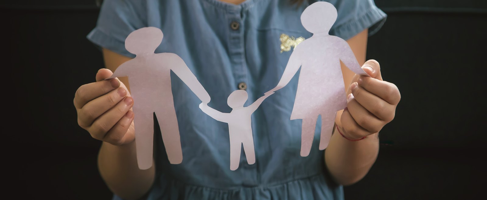A child holding a paper cutout of a family, the arrangement behind custody and visitation