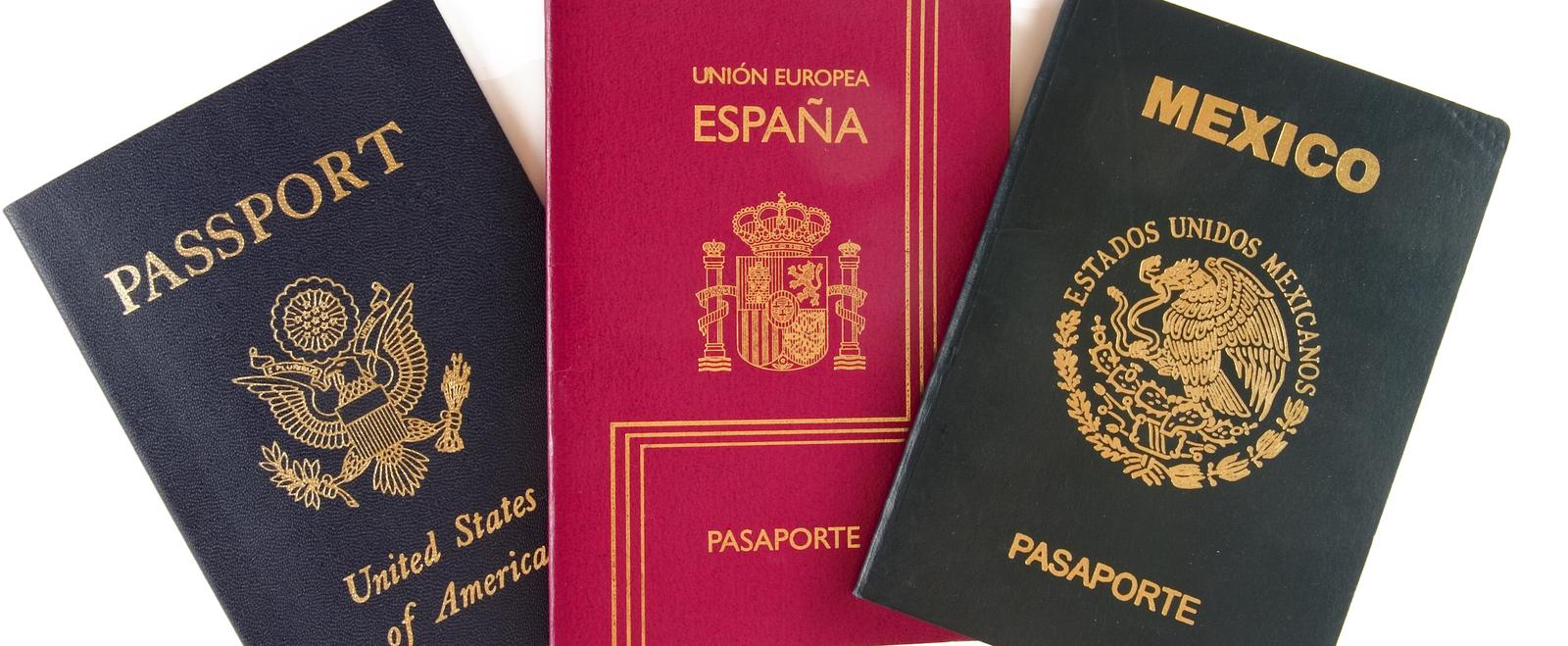 United States, Spanish and Mexican passports side by side, held by someone with dual citizenship