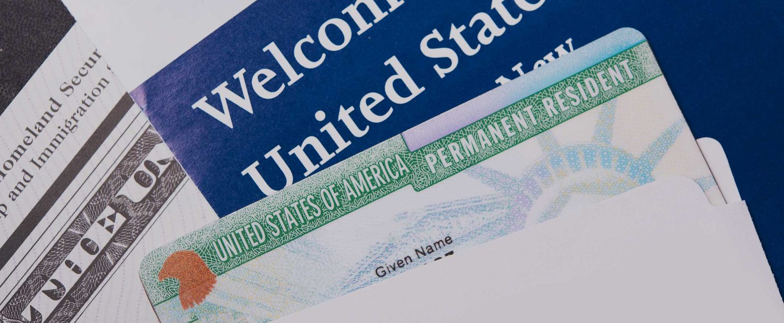 A Welcome to the United States packet holding a permanent resident green card
