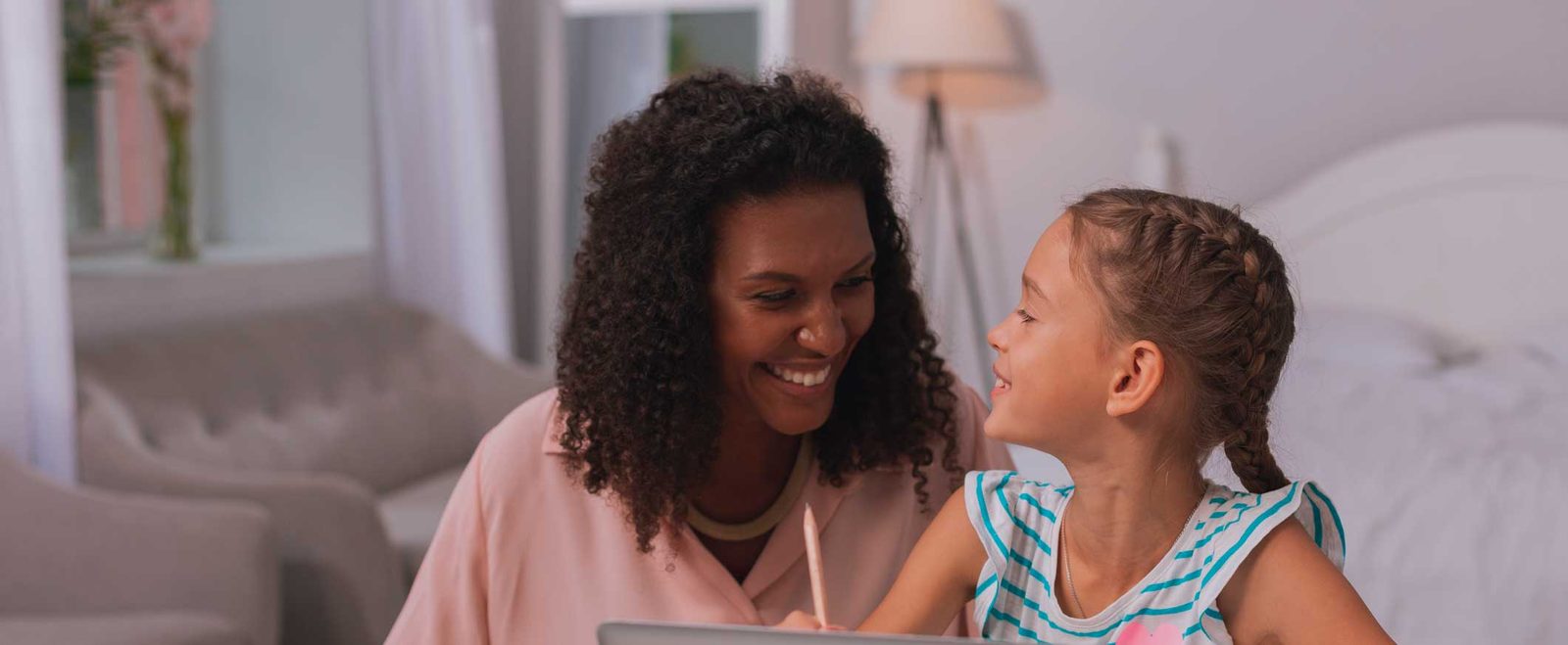 A mother and young daughter smiling at each other after an international adoption