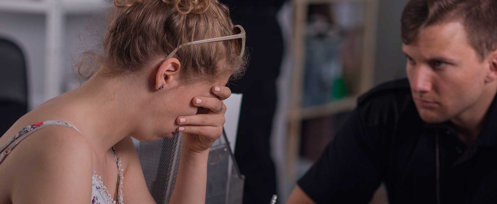 A distressed crime victim resting her head in her hand, who may qualify for a U visa