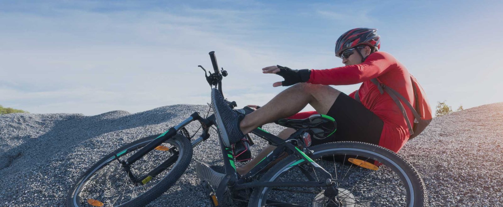 A cyclist on the ground beside their bike after a bicycle accident