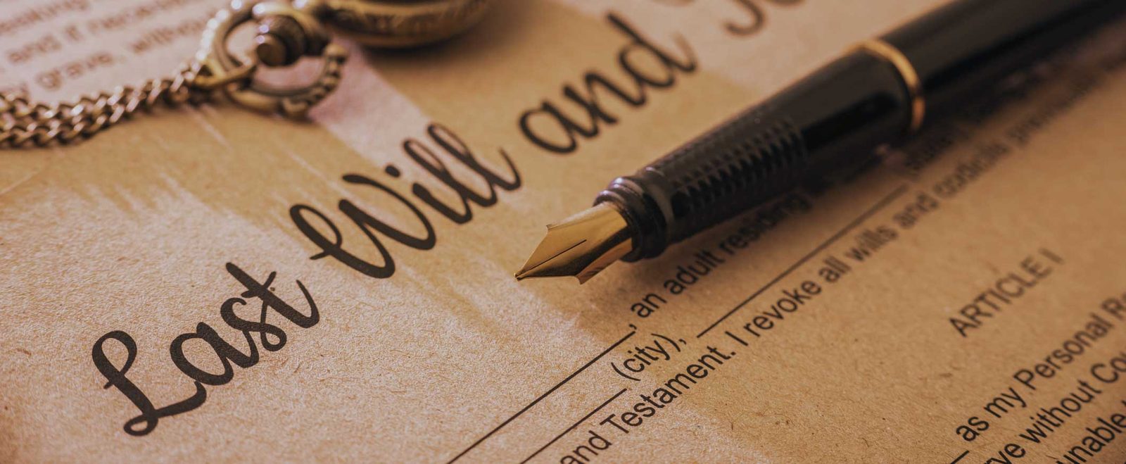 A last will and testament document with a fountain pen resting on it